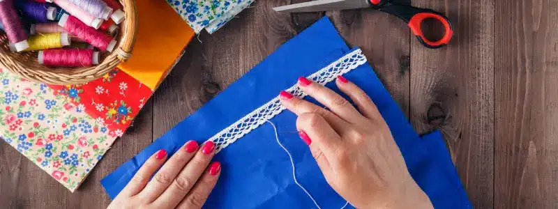 Sewing your way to financial freedom. Turn hobbies into a profitable side hustle, as shown in this image of someone sewing lace onto fabric