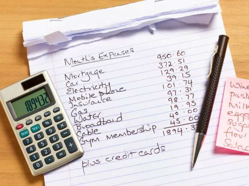 Frugal money saver planning their budget with a calculator and notebook